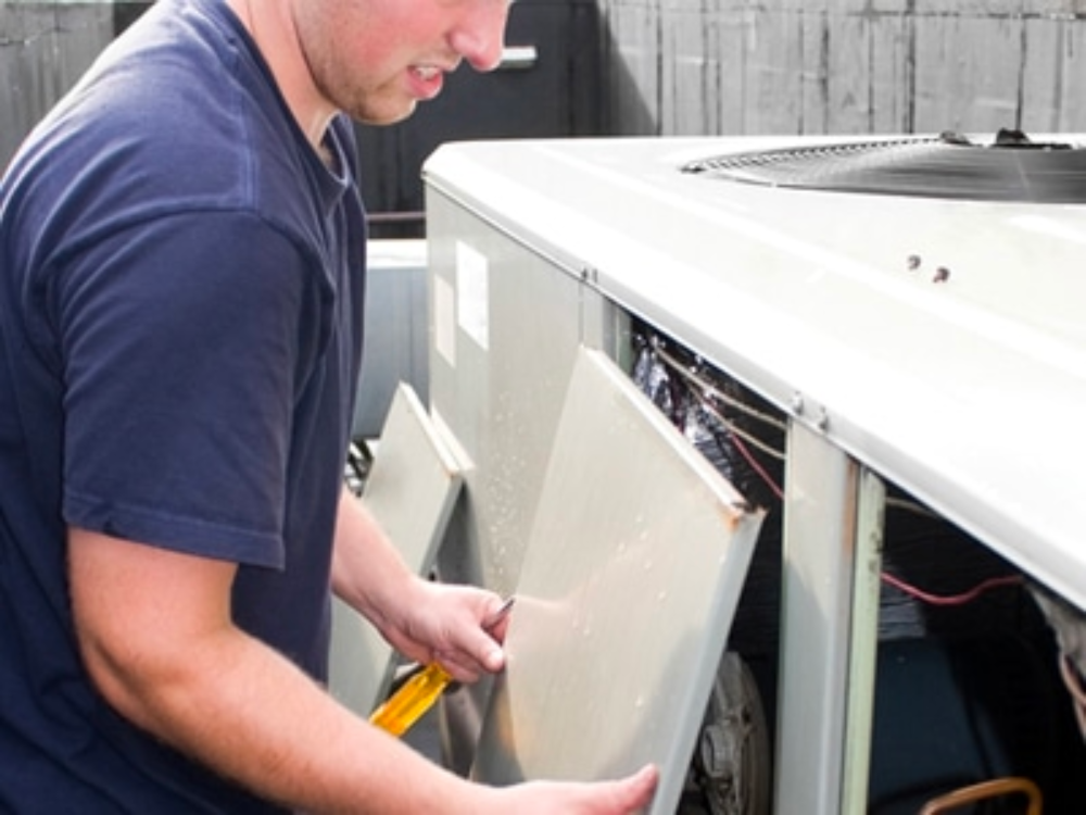 D&D Heating & Cooling: Heat Pump Repair in Macungie, PA [Technician replacing door on HVAC unit]